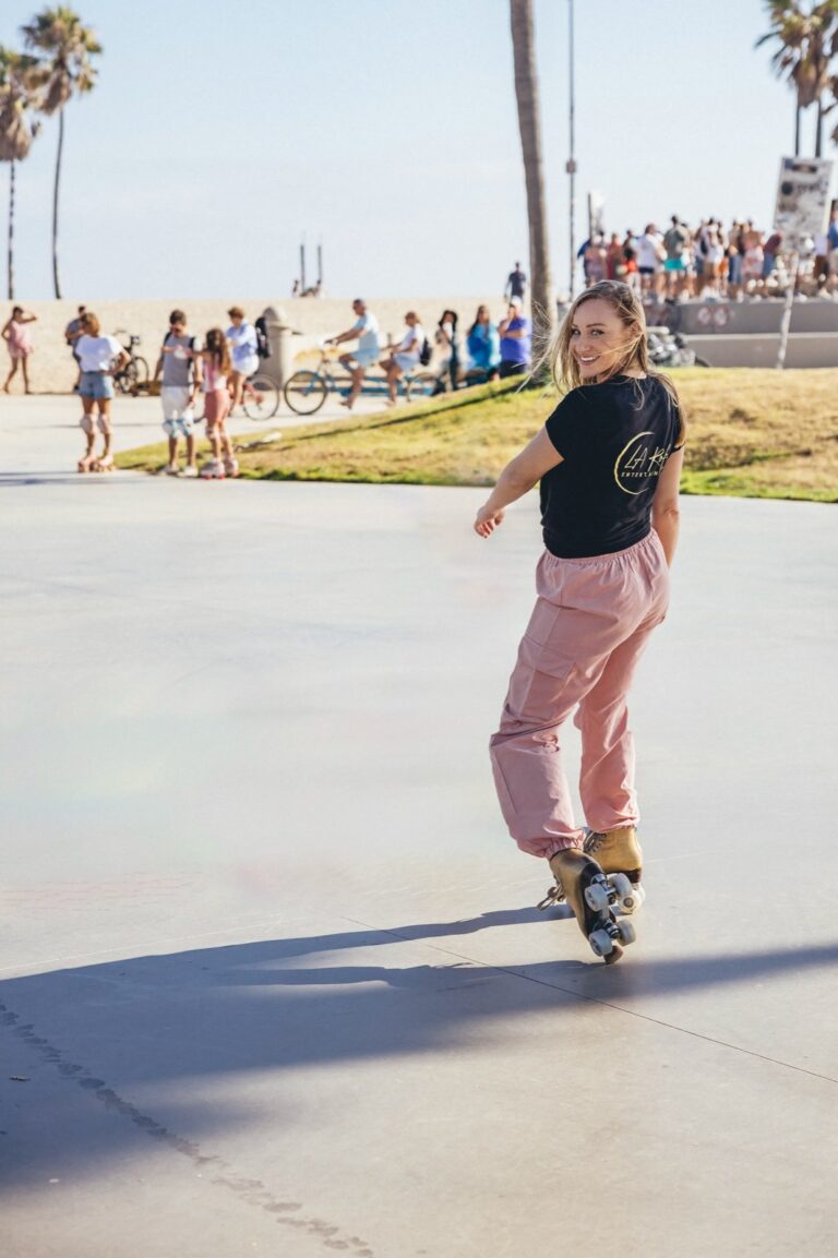 fille blonde souriante en train de faire du patins à Venice Beach en Californie