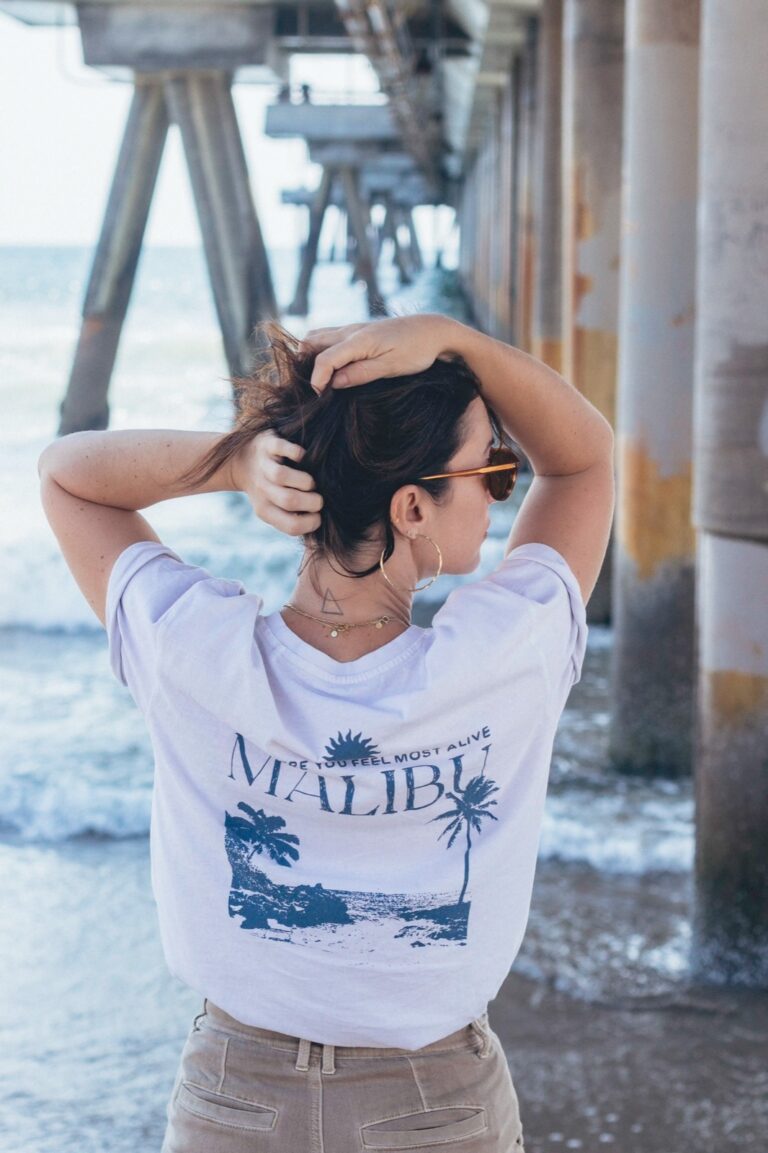 fille de dos ramenant ses cheveux sur le haut de la tête lors d'une séance photo sous le pier de Venice Beach avec un photographe français